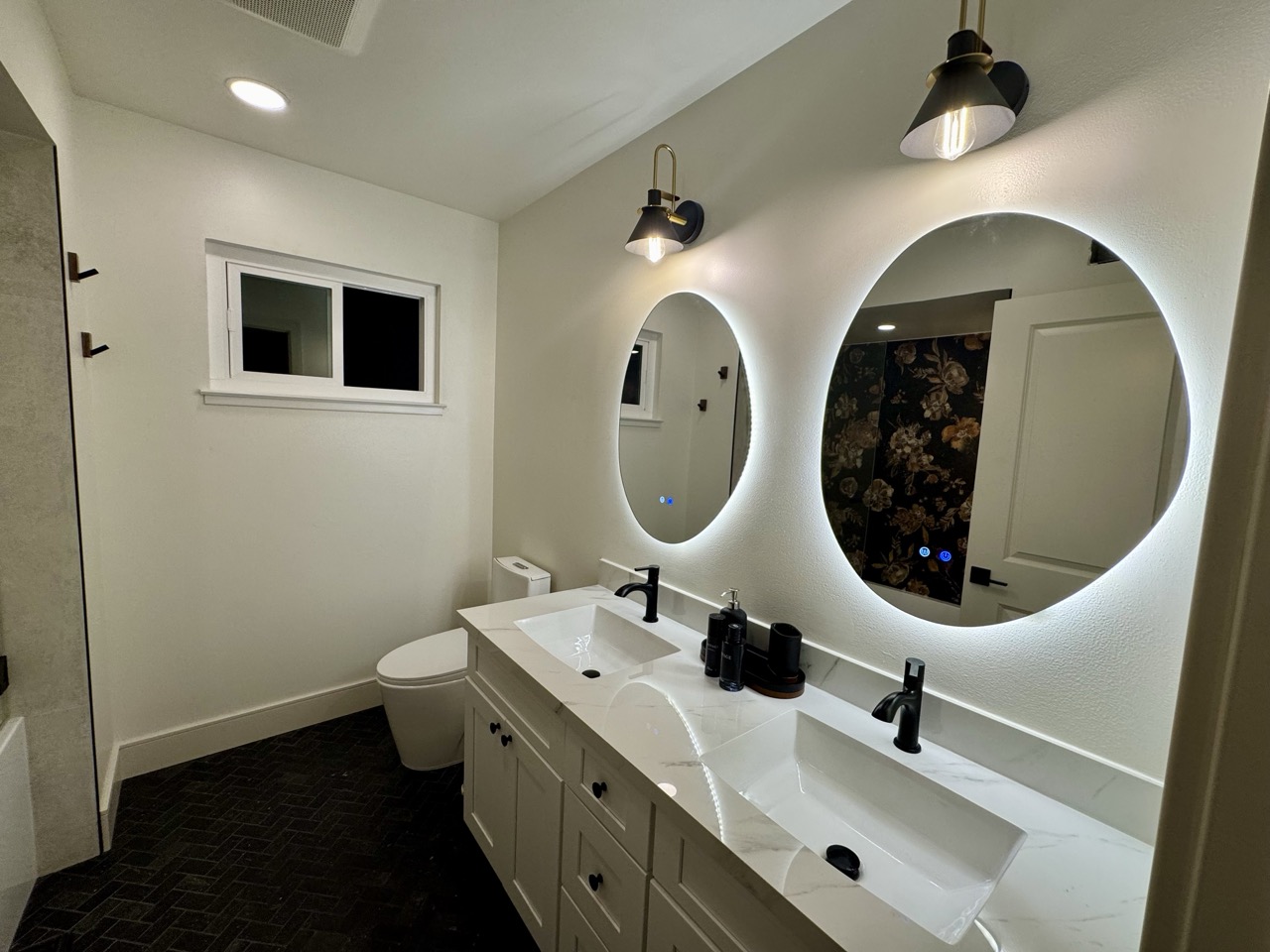 Guest bath after — double vanity with backlit round mirrors