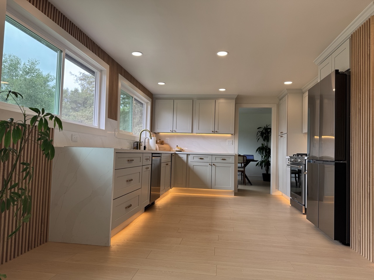 Kitchen after remodel showing quartz waterfall counter and window wall