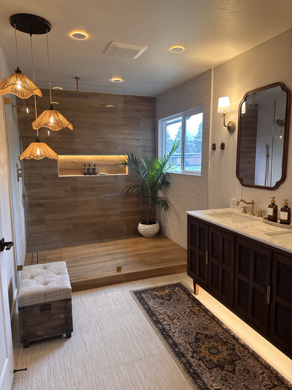 Primary bath after — wood-look tile shower with rattan pendants