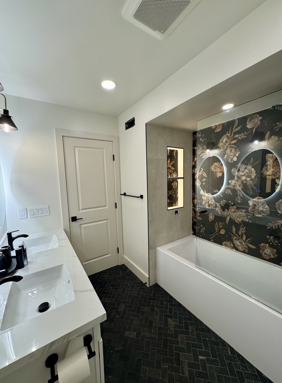 Guest bath after — floral feature wall, herringbone slate floor, double vanity