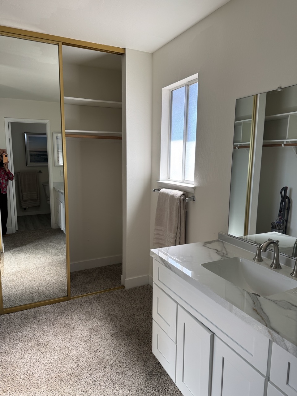 Primary bathroom before remodel with mirrored closet and carpet